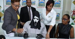 Il vincitore della lotteria incassa il suo assegno con la maschera di Scream. Il motivo del travestimento