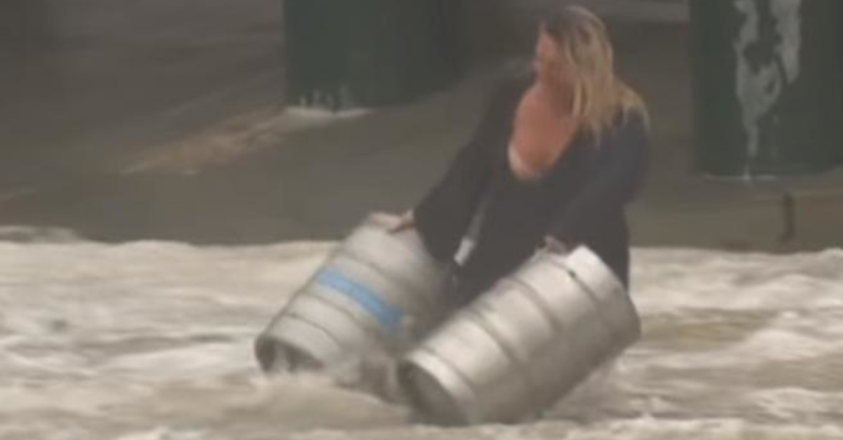 Una donna australiana scende in una strada allagata per salvare due fusti di birra Una donna australiana scende in una strada allagata per salvare due fusti di birra