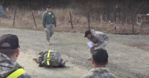 Una donna militare  finisce a terra davanti agli altri soldati, ma rifiuta di arrendersi