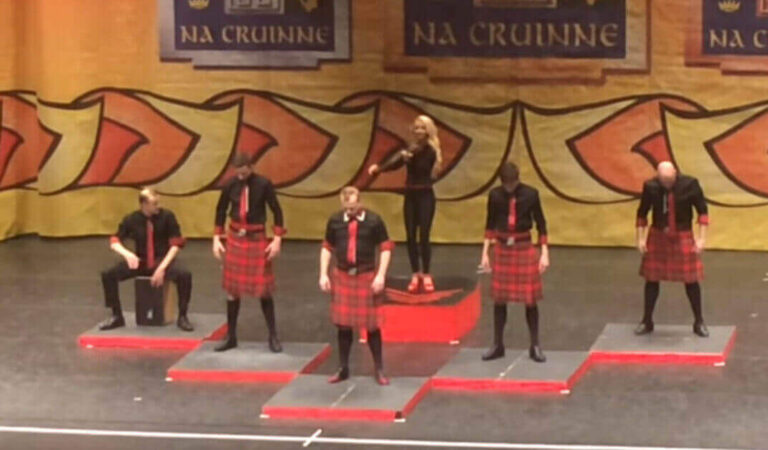 Quattro uomini in kilt salgono sul palco esibendosi in una magnifica danza irlandese Quattro uomini in kilt salgono sul palco esibendosi in una magnifica danza irlandese