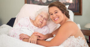 La sposa fa un servizio fotografico con la nonna che non puo’ alzarsi dal letto d’ospedale