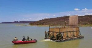 I soccorritori riescono a trasportare una giraffa attraversando un lago pieno di coccodrilli