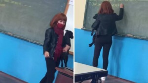 La maestra prende in braccio un cane che è entrato spaventato nella sua classe