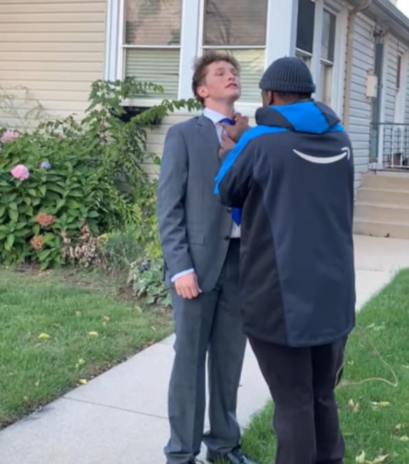 corriere Amazon aiuta un adolescente a indossare la cravatta