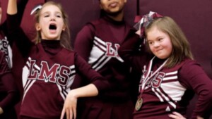 Bulli deridono la cheerleader con la sindrome di Down, ma i giocatori di basket bloccano la partita per difenderla
